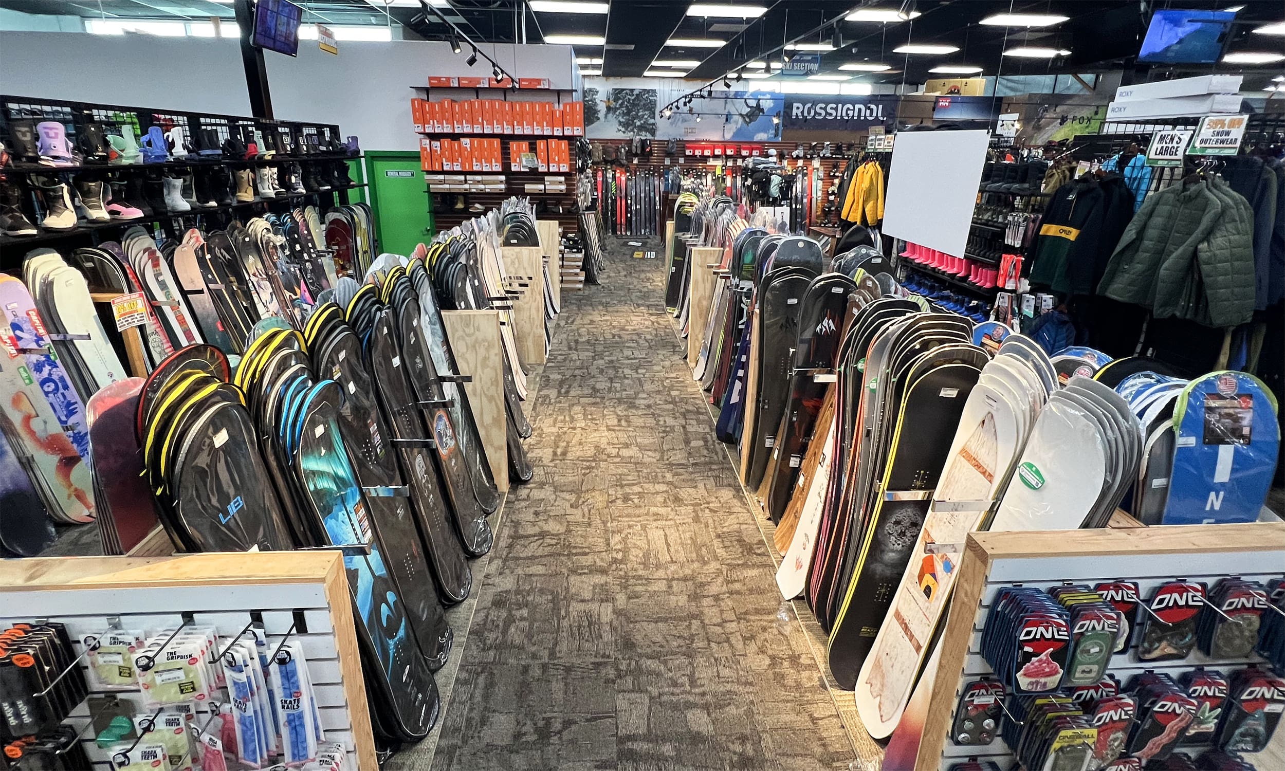 A long hallway with many different types of skis on it.