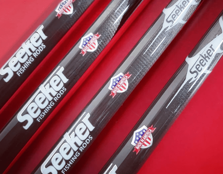 A close up of three baseball bats on a red surface