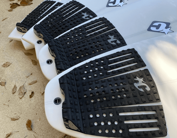 A close up of the four black and white surfboards.
