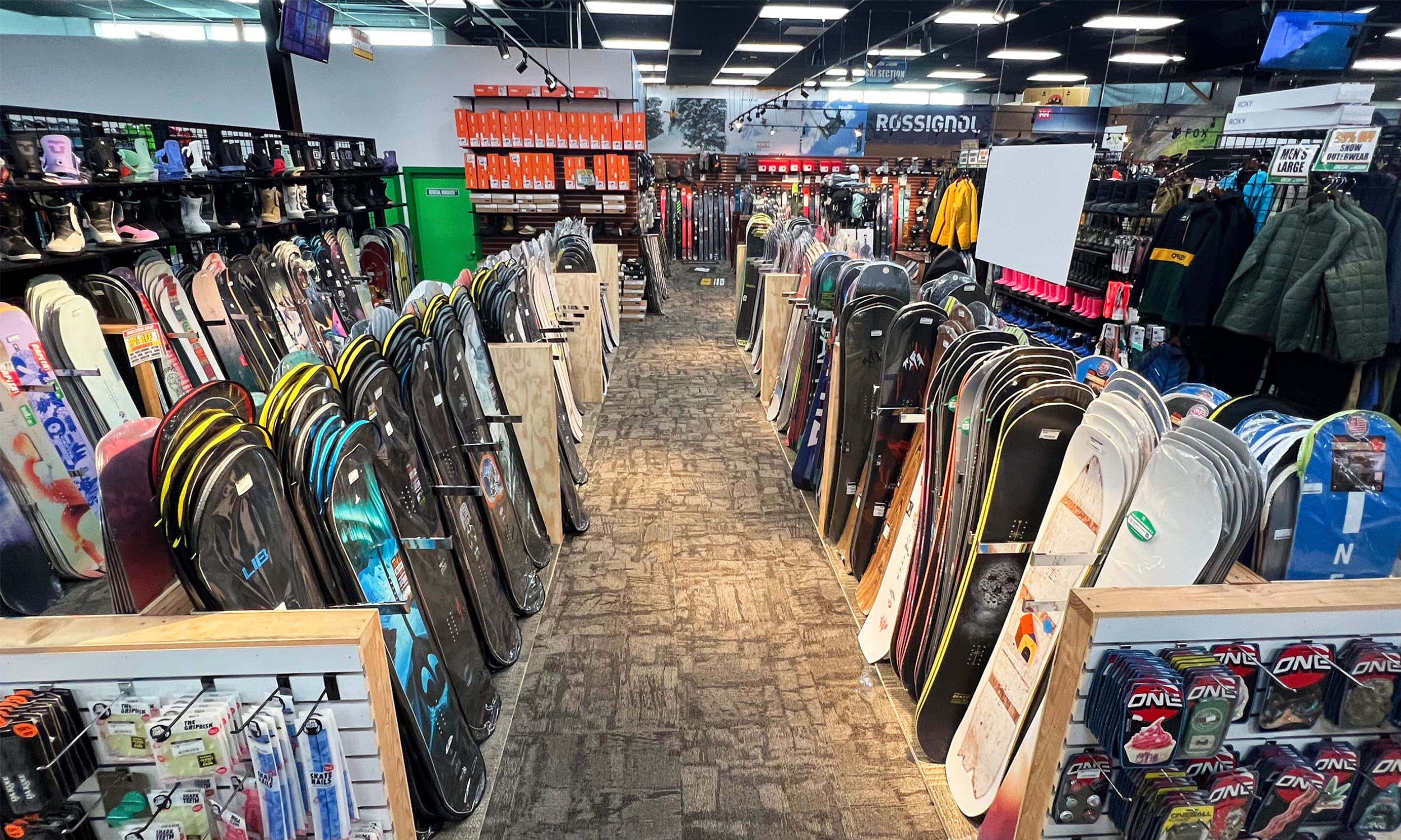 A long row of skis in the middle of a store.
