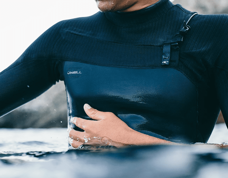 A person in a wet suit holding their stomach